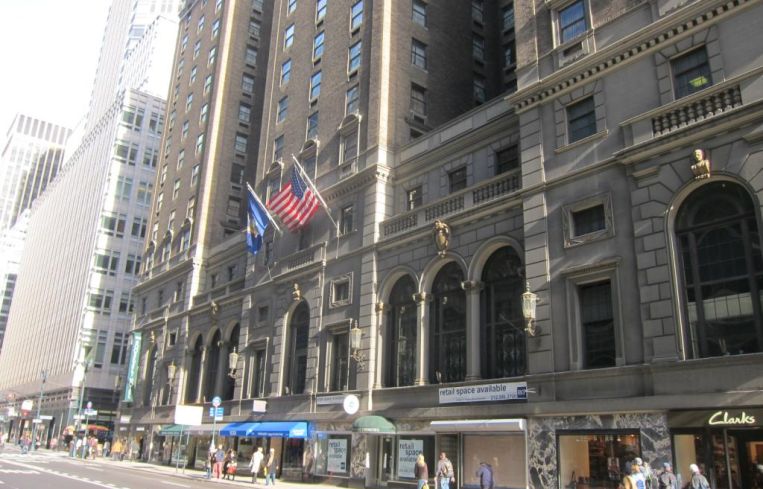 A large hotel along a sidewalk.