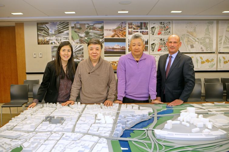 Helen and Michael Lee, Sunny Chiu and Michael Meyer of F & T Group standing above the firm's 3D map of Downtown Flushing in its Queens Crossing offices. (Photo: F&T Group). 
