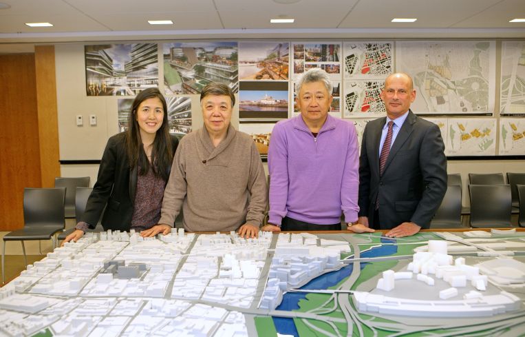 Helen and Michael Lee, Sunny Chiu and Michael Meyer of F & T Group standing above the firm's 3D map of Downtown Flushing in its Queens Crossing offices. (Photo: F&T Group).