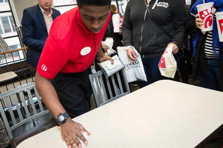 Employee cleans the table between customers at the Chick-fil-A at 1000 Avenue of the Americas (Photo: Kaitlyn Flannagan/Commercial Observer).