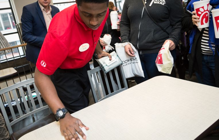 Employee cleans the table between customers at the Chick-fil-A at 1000 Avenue of the Americas (Photo: Kaitlyn Flannagan/Commercial Observer).