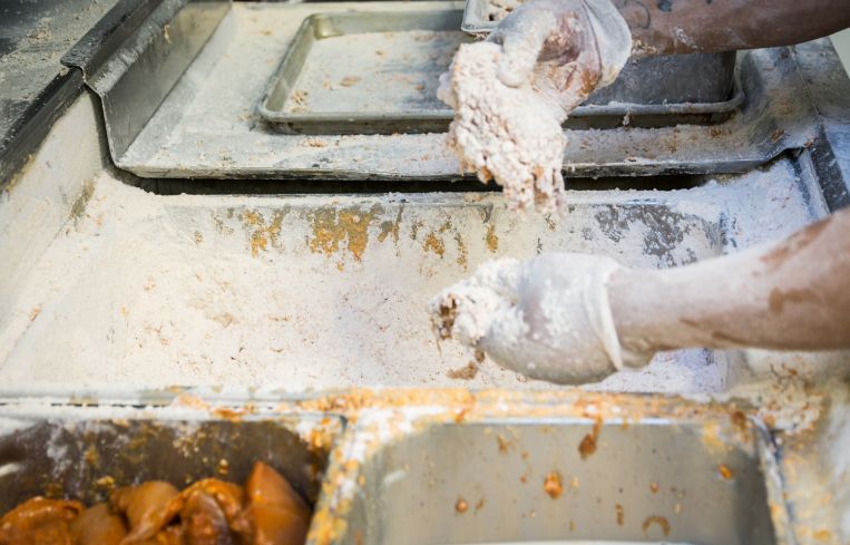 Employee coating the chicken breasts in what is considered Chick-fil-A's "secret sauce" at 1000 Avenue of the Americas (Photo: Kaitlyn Flannagan/Commercial Observer).