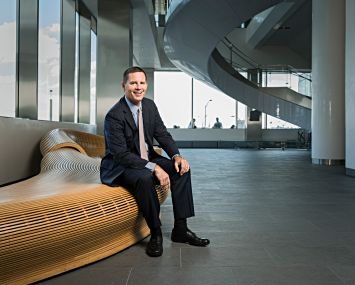 John Cunningham sits in the Alexandria Center for Life Science lobby.