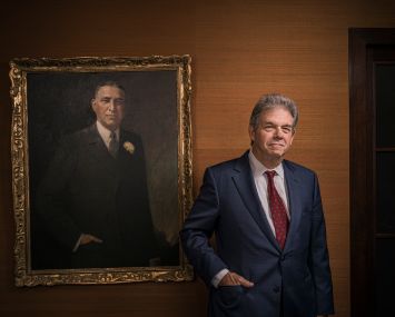 Steven Kaufman stands in front of a portrait of his late grandfather, Samuel Kaufman.