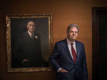Steven Kaufman stands in front of a portrait of his late grandfather, Samuel Kaufman. 