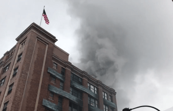 Smoke billows from the roof of the home to Chelsea Market. Photo: NY1 