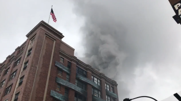 Smoke billows from the roof of the home to Chelsea Market. Photo: NY1 