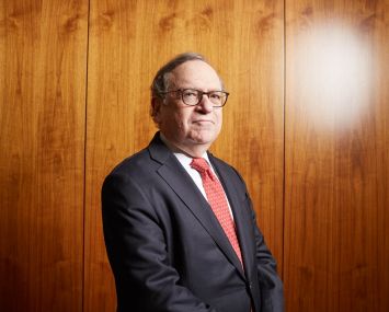 A man standing in front of a wall with glasses