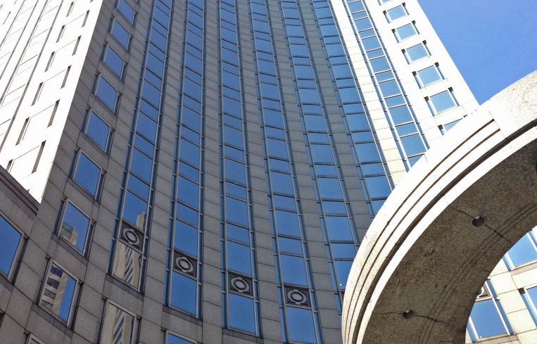 A soaring skyscraper closeup, looking up from the ground.