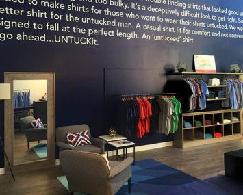 Inside the Soho store of Untuckit. While each store is tailored to its location, they all have a wall outlining the Untuckit story.