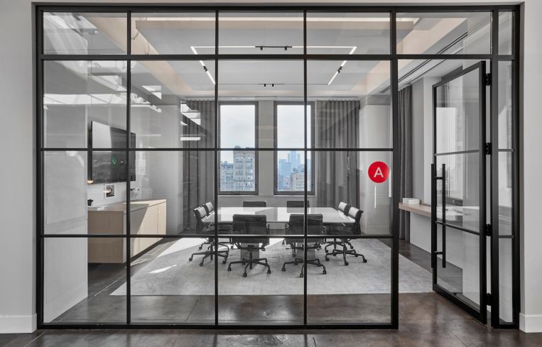 Meeting and private rooms at Winton Capital’s offices at 315 Park Avenue South have glassed walls with black metal framing in a grid pattern.