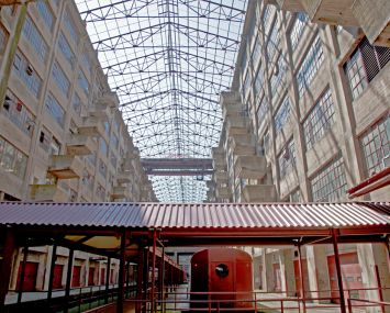 The atrium of Building B at the Brooklyn Army Terminal features an open skylight, dozens of loading docks and a disused train.