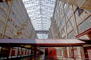 The atrium of Building B at the Brooklyn Army Terminal features an open skylight, dozens of loading docks and a disused train. 