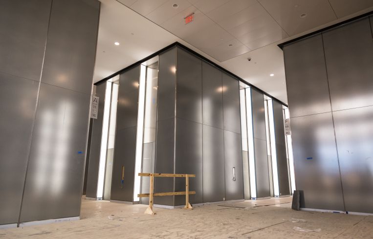 Light reflecting off the woven metal panels that are covered by sheets of glass on the lobby.