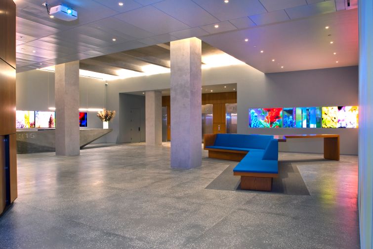 The former lobby of 315 Park Avenue South featured wooden furniture, concrete floors and gray walls and flashy artwork.
