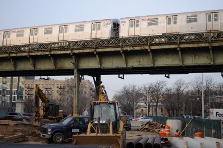 A subway train passes above a construction site in Williamsburg.