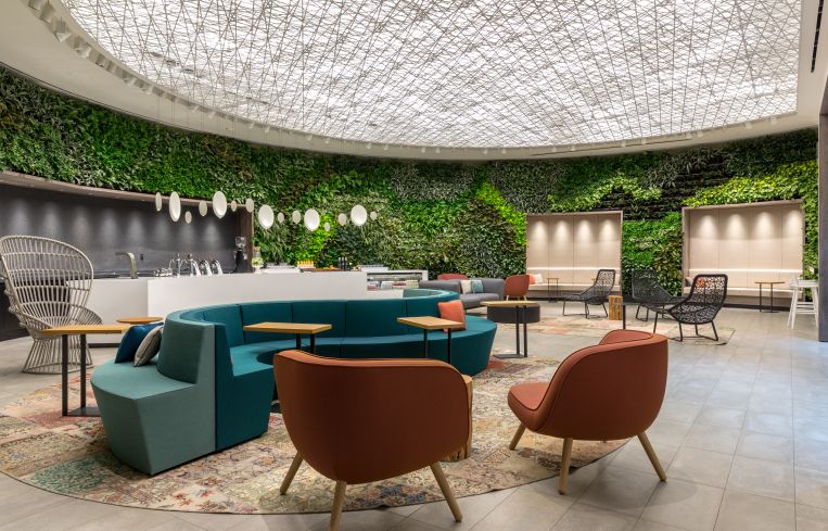"The Green" room on the amenity floor at 4 Times Square features a 106-foot long floor to ceiling plant wall, a bar with beer and wine on tap and a variety of seating options for tenants to work at or relax in.