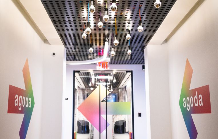 Off the elevators, giant colorful arrows and hanging light bulbs lead guests to Agoda's space. lightbuild