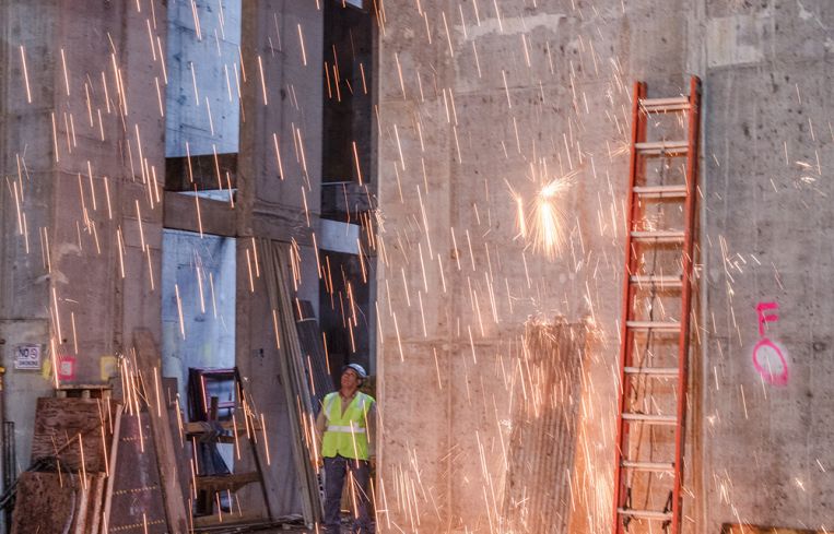 Sparks fly as laborers work on the lobby of the building.