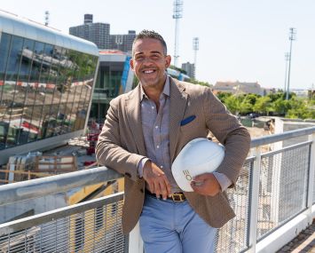 Joseph Ferrara of BFC Partners with his Empire Outlets project behind him.