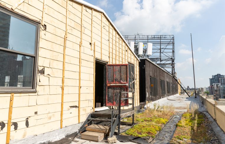 The yellow sheds on either end of the roof will be torn down, reconfigured and the roof deck will get new pavers at 43-10 23rd Street.
