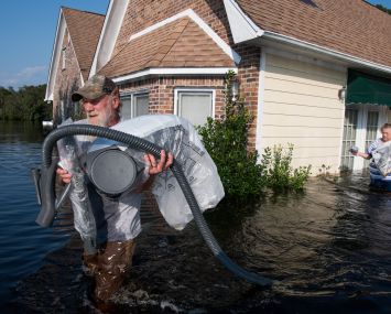 A man in Longs, S.C. helps remove valuables from a friend's house amidst flooding from Hurricane Florence.