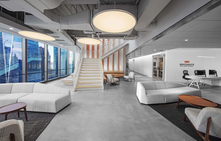 One firm, Wavemaker, has a muted seating area with orange accents and light wood.