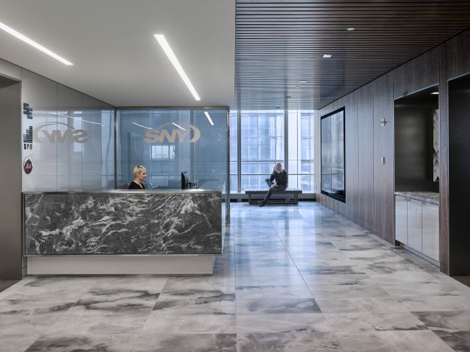 A formal reception area with marble floors for SportsNet contrasts with the rest of its office.