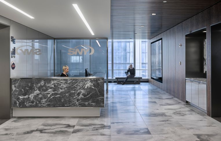 A formal reception area with marble floors for SportsNet contrasts with the rest of its office.