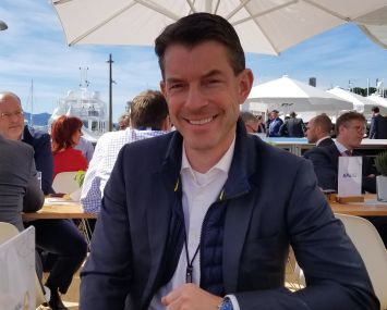 Commerz Real CEO Andreas Muschte at his company's outdoor table in the Frankfurt pavilion at MIPIM.