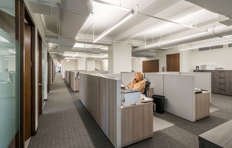 Much of the office is designed in grays, whites and walnut wood.