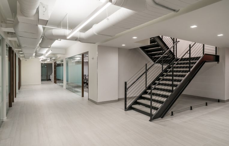 Designer Tamara Eaton tried to carry the industrial vibe of the column into other parts of the office using a black metal staircase.