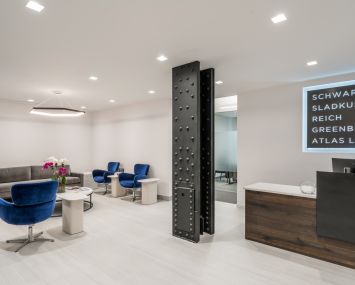 Schwartz Sladkus Reich Greenberg Atlas' new offices at 444 Madison Avenue feature an exposed metal column and blue modernist chairs in the reception area.