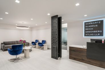 Schwartz Sladkus Reich Greenberg Atlas' new offices at 444 Madison Avenue feature an exposed metal column and blue modernist chairs in the reception area.
