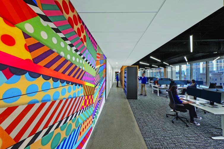 Brightly colored, street-art style wall decorations adorn the wall between the work area and lockers.