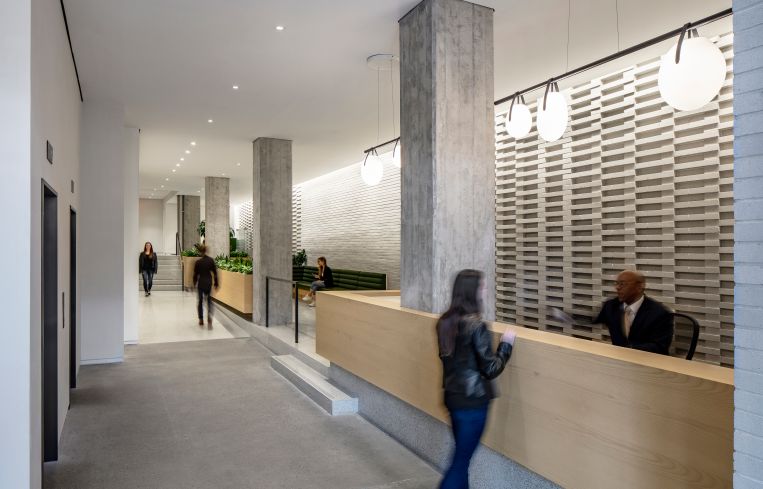A+I widened the narrow lobby at 155 Avenue of the Americas and added a patterned brick wall to make the space more interesting.