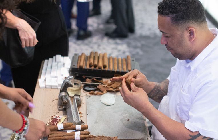 Greystone’s Karen Marotta looks on as cigars are rolled at the bar sponsored by Stroock & Stroock & Lavan.