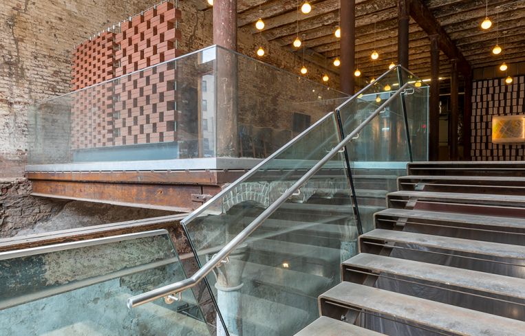 A glass railing and open staircase showcases the Malt Building's historic past while providing a unique entry for a future retail tenant.