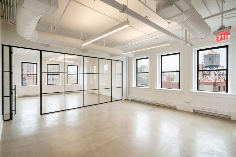 Part of the prebuilt office is divided into a conference room with a paneled glass wall.