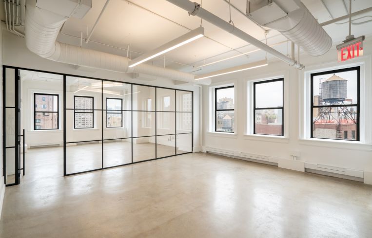 Part of the prebuilt office is divided into a conference room with a paneled glass wall.
