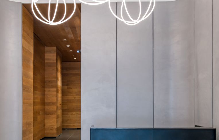 The 18-foot-tall lobby was renovated with wooden and concrete walls and a neon chandelier-sculpture made by Precision Neon.