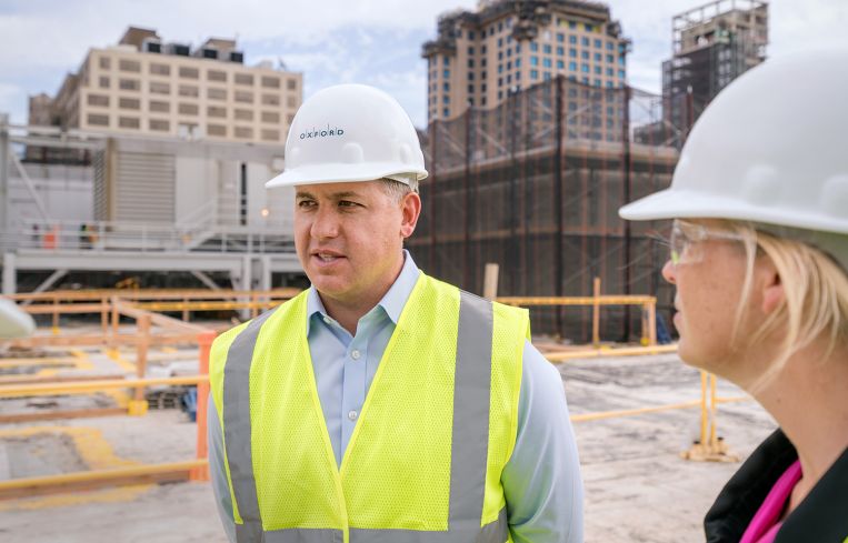 Oxford’s leasing pro Adam Frazier and Kate Bicknell, development lead, on the building’s fourth floor roof, which will be razed in preparation for a nine-story addition.