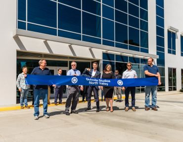 Mikel Elliott (center), the CEO of Quixote Studios, is flanked by colleagues and local officials as he cuts the ribbon at its new facility in North Los Angeles. 
