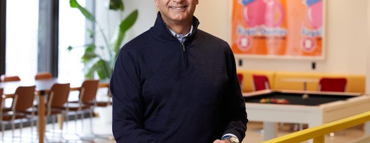 A man at a railing smiling.