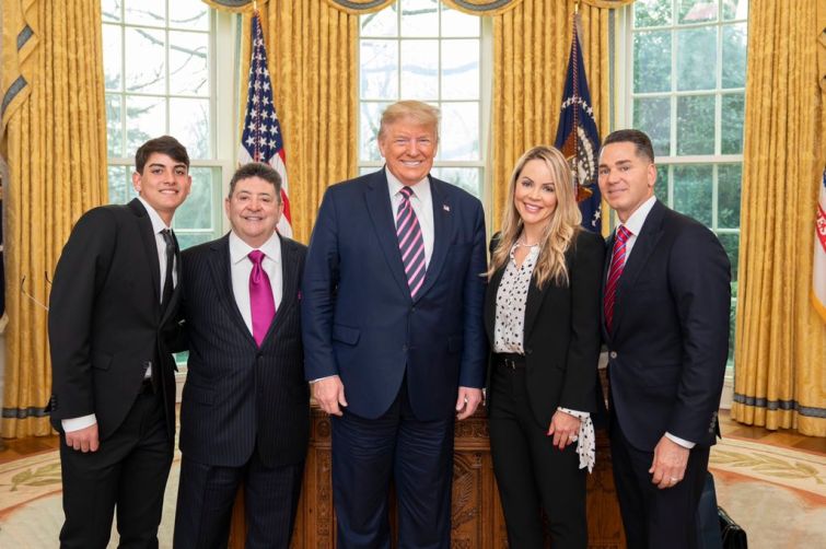 President Donald Trump, center, poses with Eddie Debartolo Jr., left center, and his family.