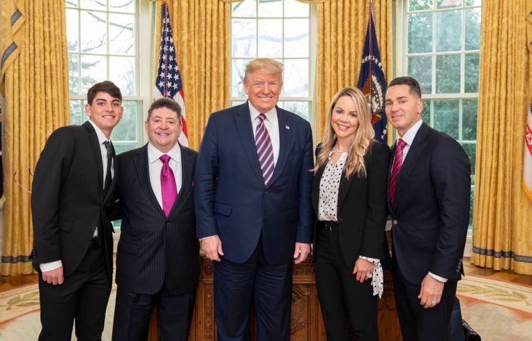 President Donald Trump, center, poses with Eddie Debartolo Jr., left center, and his family.