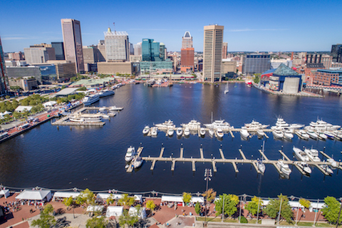 Aerial view of Baltimore's Inner Harbor area, with the Downtown skyline in the background.