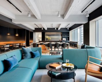 Rockefeller Group's new offices, designed by Fogarty Finger, include a 3,000-square-foot common area with mid-century modern furniture, exposed concrete ceiling and a pantry.