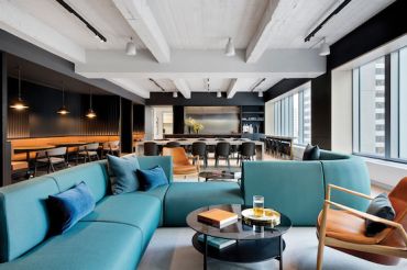 Rockefeller Group's new offices, designed by Fogarty Finger, include a 3,000-square-foot common area with mid-century modern furniture, exposed concrete ceiling and a pantry.