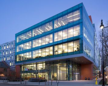 A squat, squarish office building illuminated at night.
